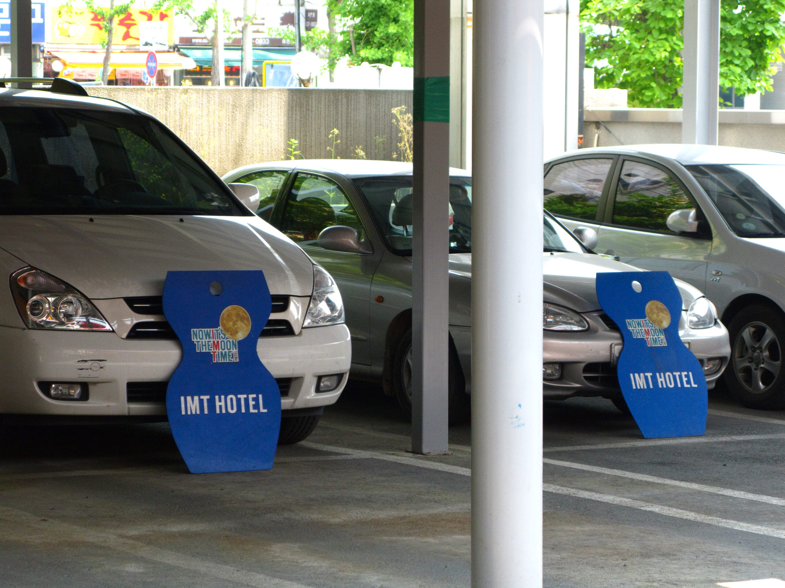 Cars parked with signs covering the license plates.